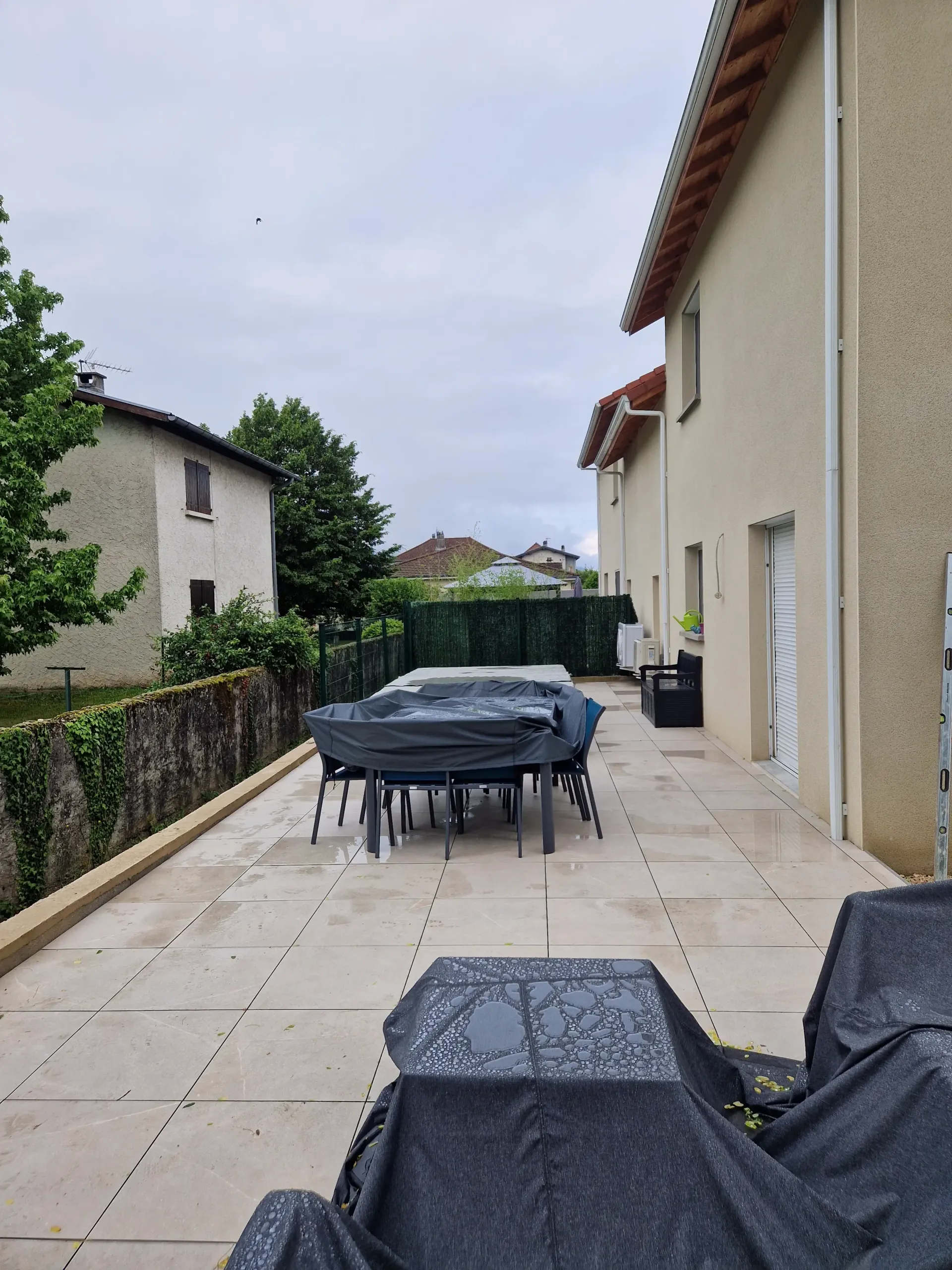une terrasse avec une table et des chaises couvertes par une couverture noire .