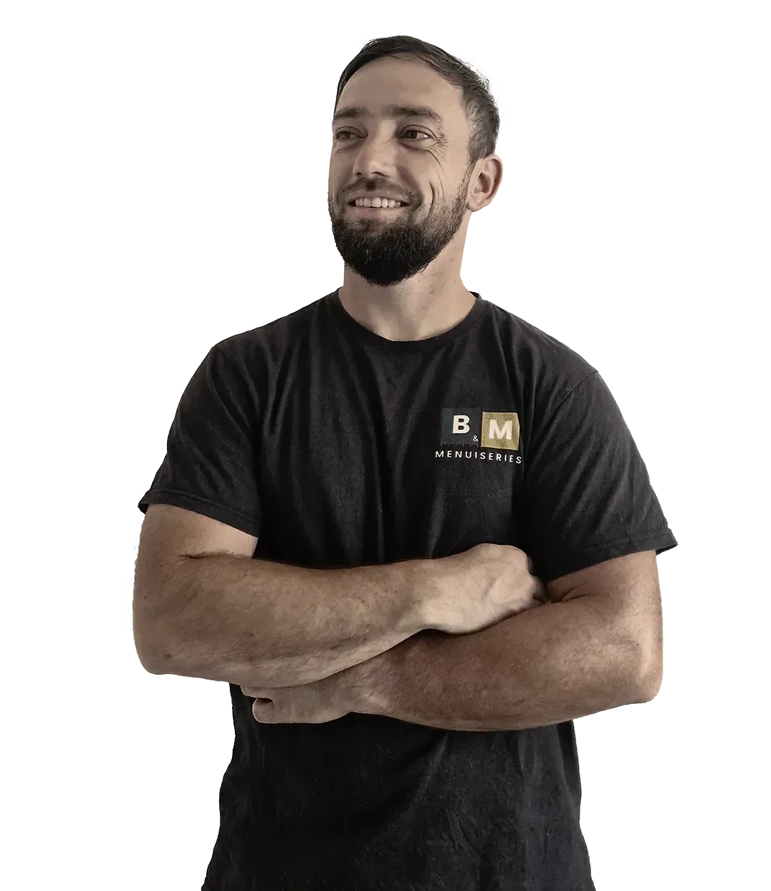 Homme barbu, bras croisés, souriant, portant une chemise noire à logo.