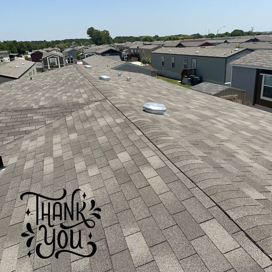 Rooftop with gray shingles and vents overlooking houses under a clear blue sky; “Thank you” text in corner