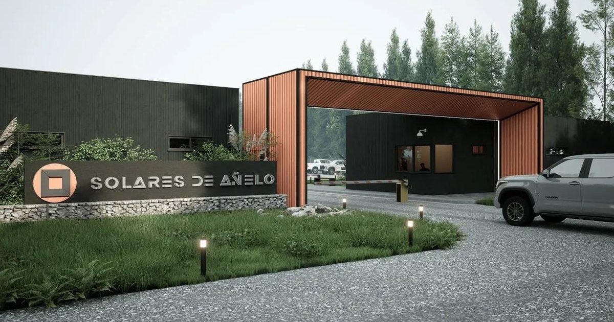 Entrada moderna a la casa con marquesina de madera, camino de grava, césped y un coche aparcado al anochecer.