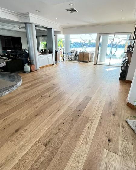 A Living Room With Hardwood Floors and Sliding Glass Doors — Totally Flooring Gold Coast In Bundall, QLD