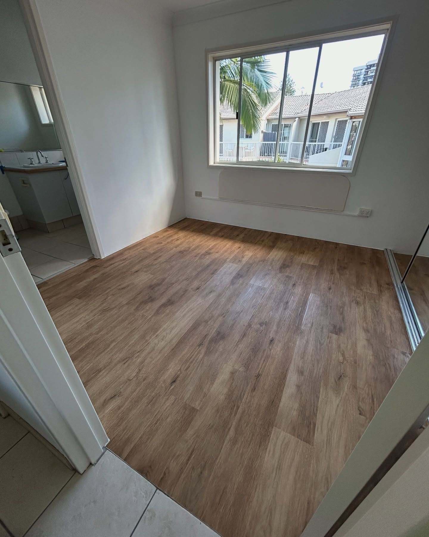Room with wood-look flooring and a window — Totally Flooring Gold Coast In Bundall, QLD