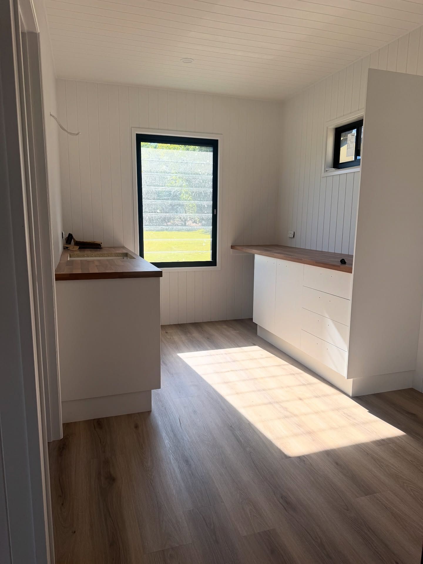 Interior view of a room with white cabinets, wood countertops — Totally Flooring Gold Coast In Bundall, QLD
