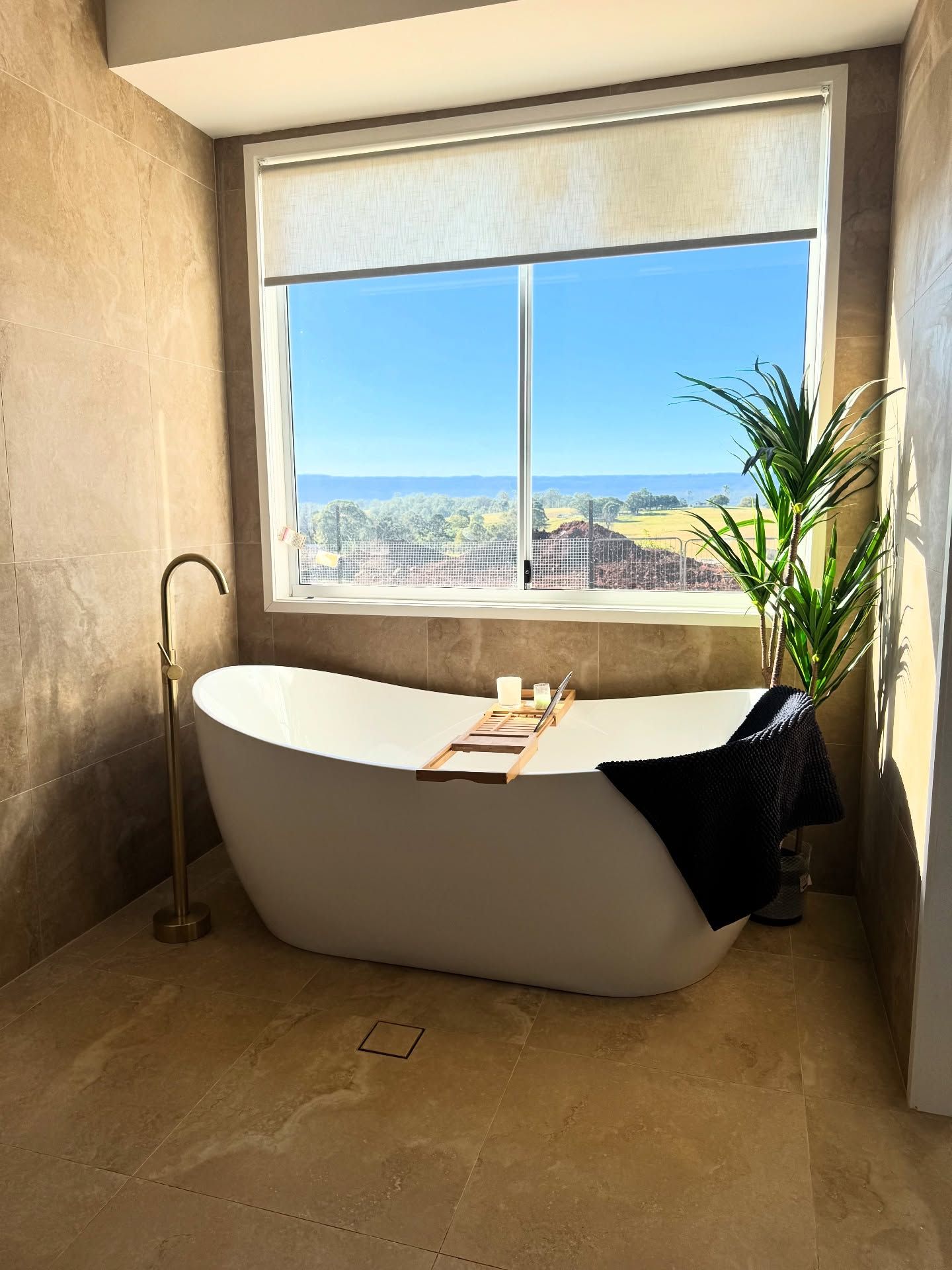 Freestanding white bathtub by a window with a coastal view — Totally Flooring Gold Coast In Bundall, QLD