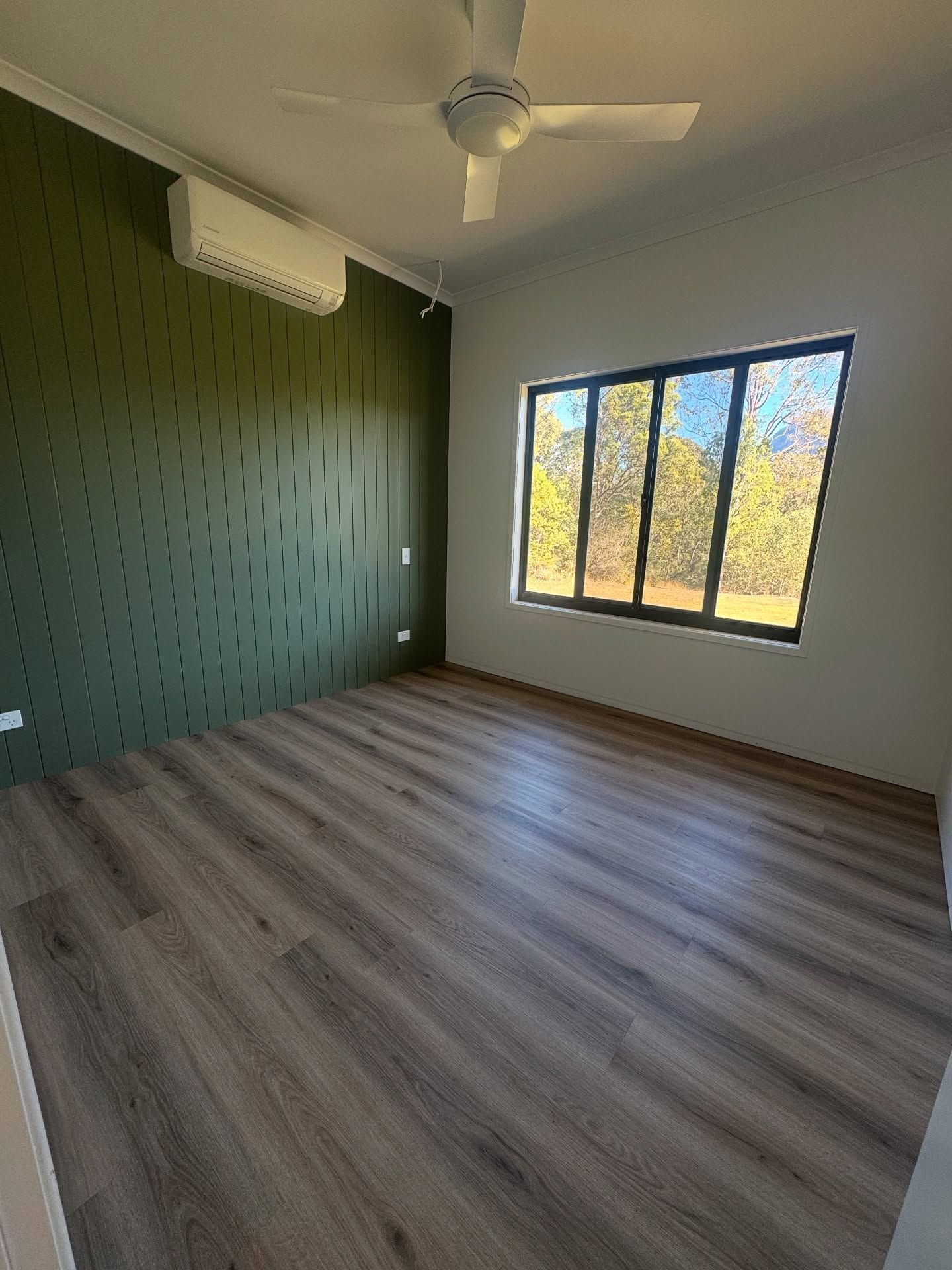 Empty room with green textured wall — Totally Flooring Gold Coast In Bundall, QLD