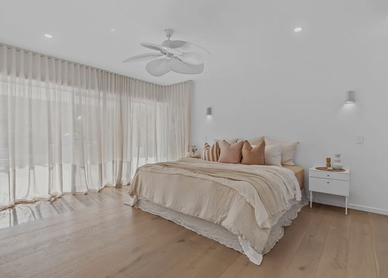 Bedroom with beige bedding — Totally Flooring Gold Coast In Bundall, QLD