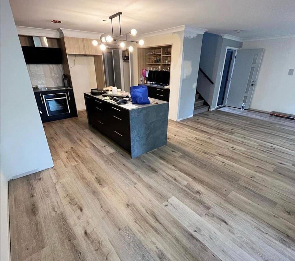 Modern Kitchen With Island, Light Wood Floors, Dark Cabinets — Totally Flooring Gold Coast In Bundall, QLD