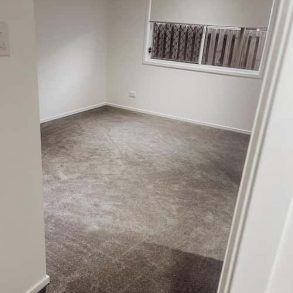 An Empty Room With a Carpeted Floor and a Window — Totally Flooring Gold Coast In Bundall, QLD