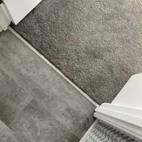 A Close Up of a Carpeted Floor Next to a Staircase — Totally Flooring Gold Coast In Bundall, QLD