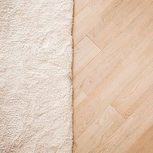 A White Rug is Next to a Wooden Floor — Totally Flooring Gold Coast In Bundall, QLD