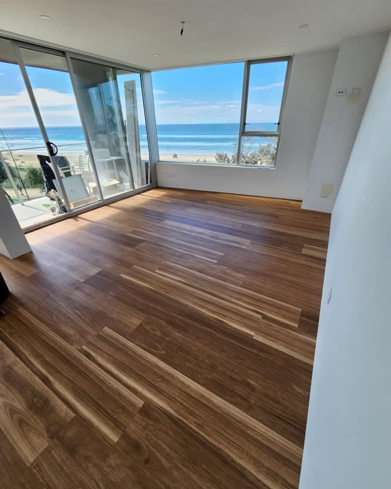 A Living Room With Hardwood Floors and a View of the Ocean — Totally Flooring Gold Coast In Bundall, QLD