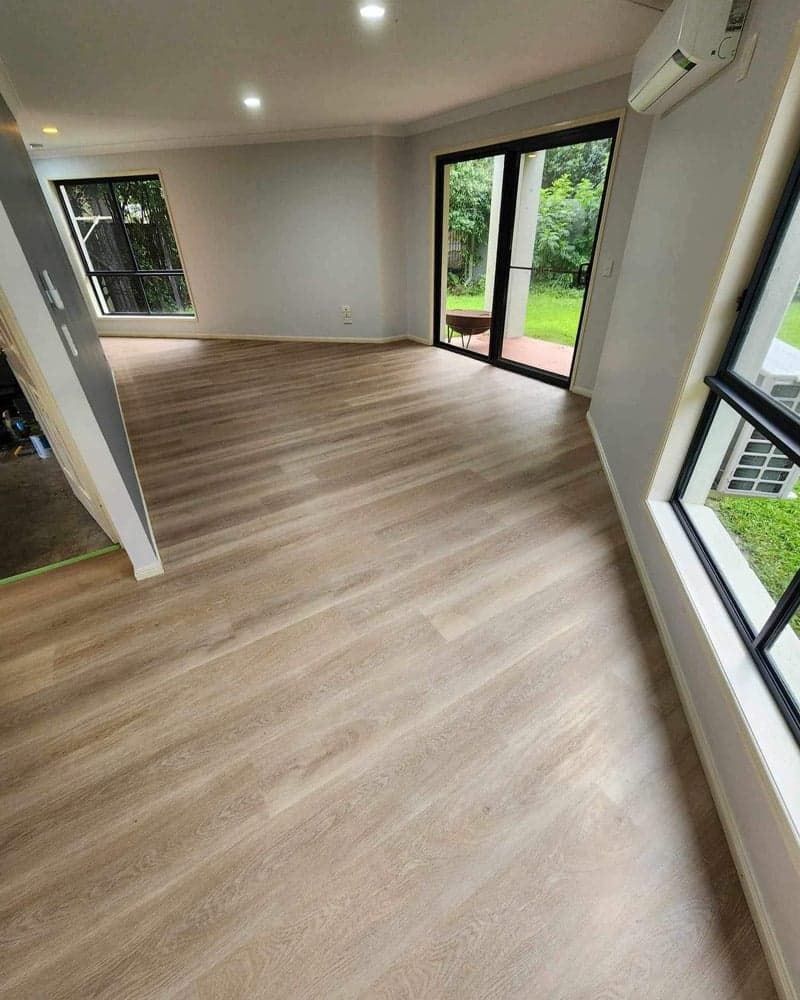 A Living Room With a Wooden Floor and Sliding Glass Doors — Totally Flooring Gold Coast In Bundall, QLD
