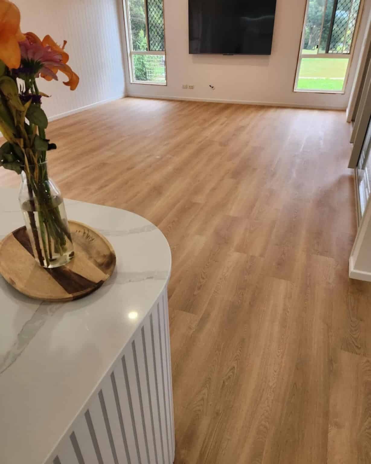 A Vase of Flowers is Sitting on a Table in a Living Room — Totally Flooring Gold Coast In Bundall, QLD