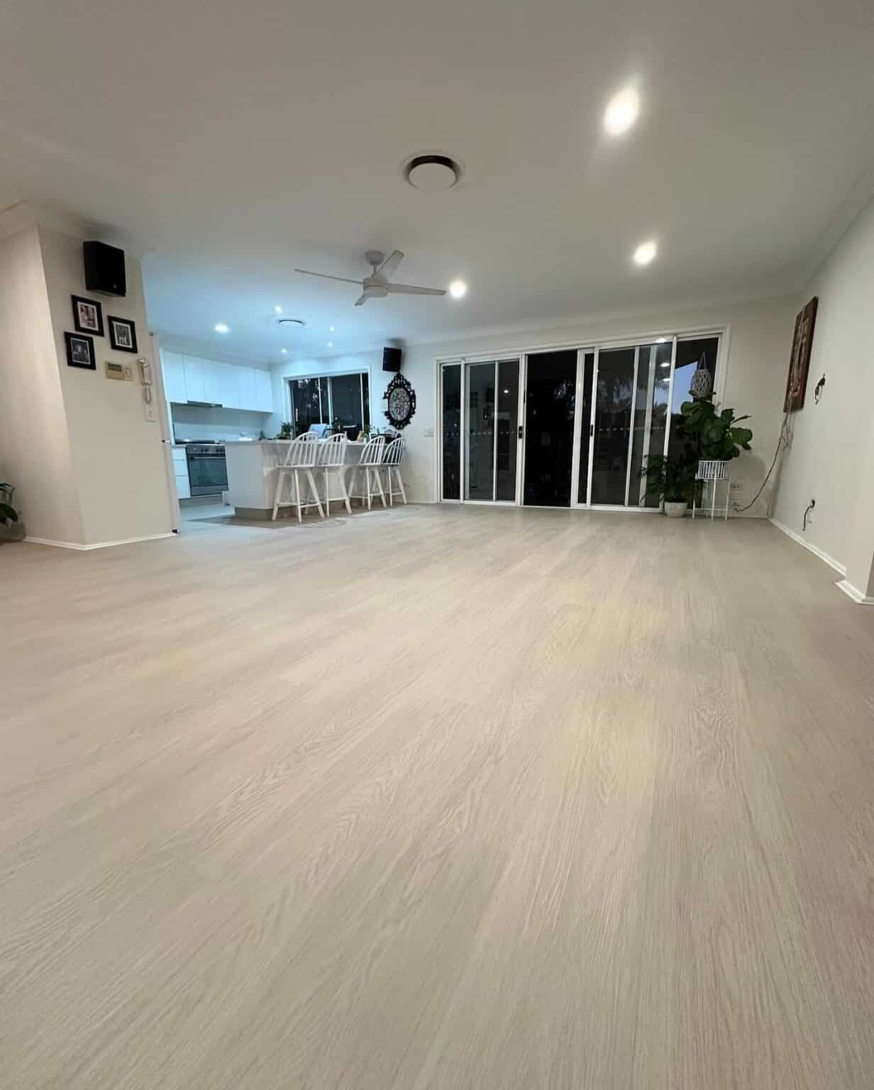 A Large Living Room With Hardwood Floors and a Ceiling Fan — Totally Flooring Gold Coast In Bundall, QLD
