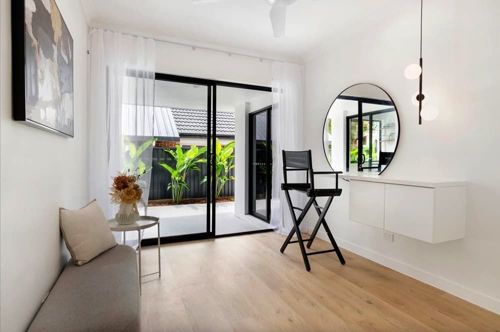 A Living Room With a Couch, Chair, Mirror and Sliding Glass Doors — Totally Flooring Gold Coast In Bundall, QLD