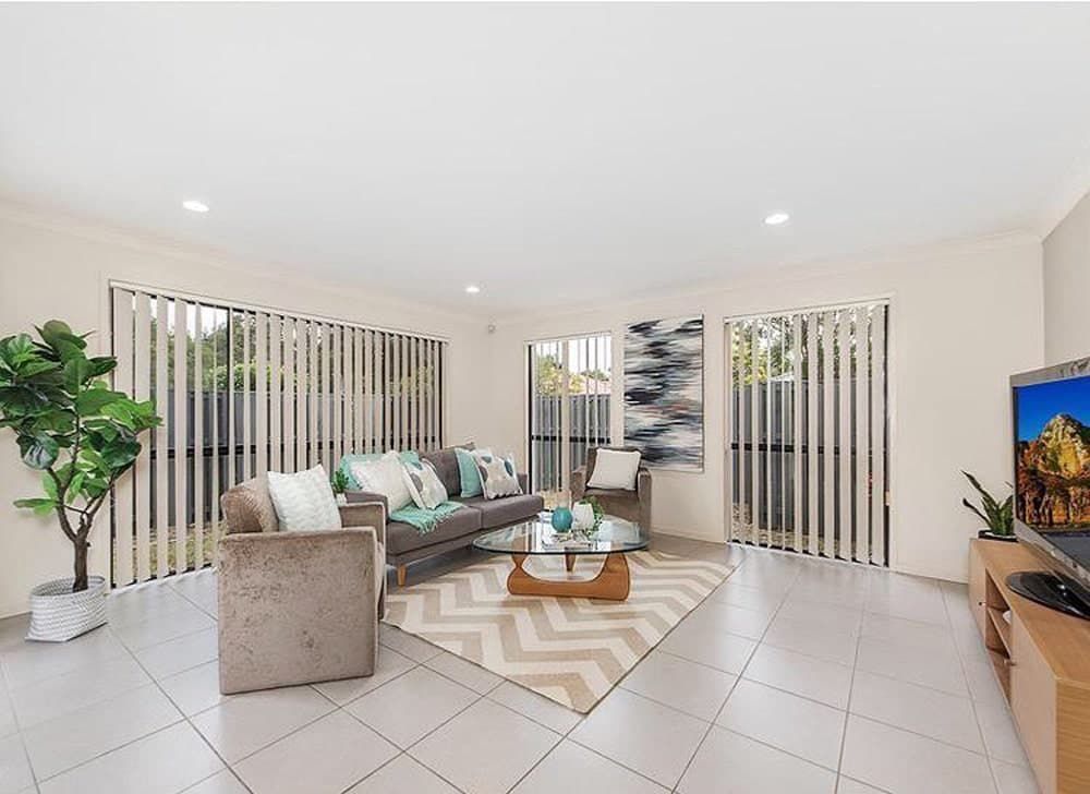 A Living Room With a Couch, Chairs, Coffee Table and Television — Totally Flooring Gold Coast In Bundall, QLD