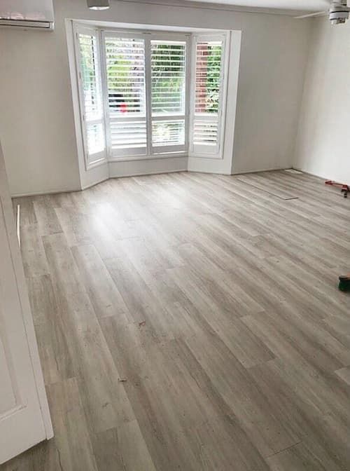 An Empty Room With a Wooden Floor and Shutters on the Windows — Totally Flooring Gold Coast In Bundall, QLD