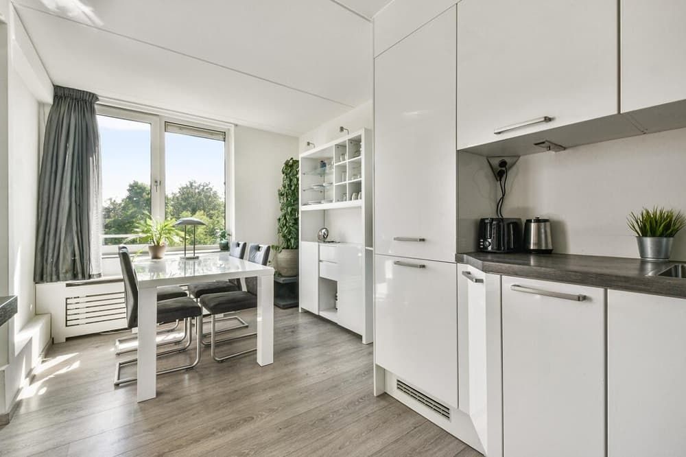 A Kitchen With White Cabinets, a Table and Chairs — Totally Flooring Gold Coast In Bundall, QLD