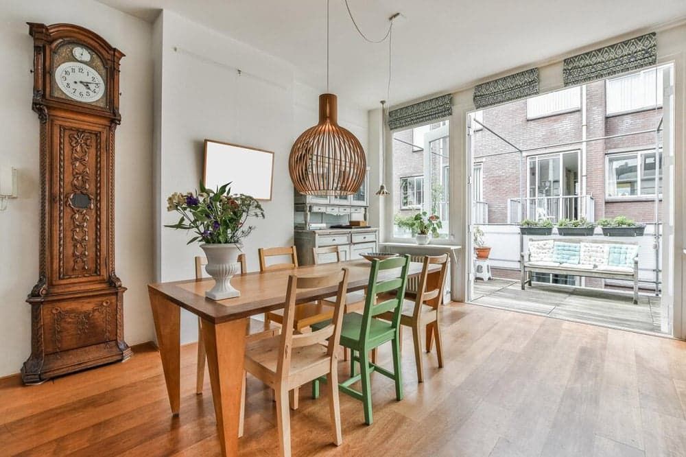 A Dining Room With a Table and Chairs and a Grandfather Clock — Totally Flooring Gold Coast In Bundall, QLD