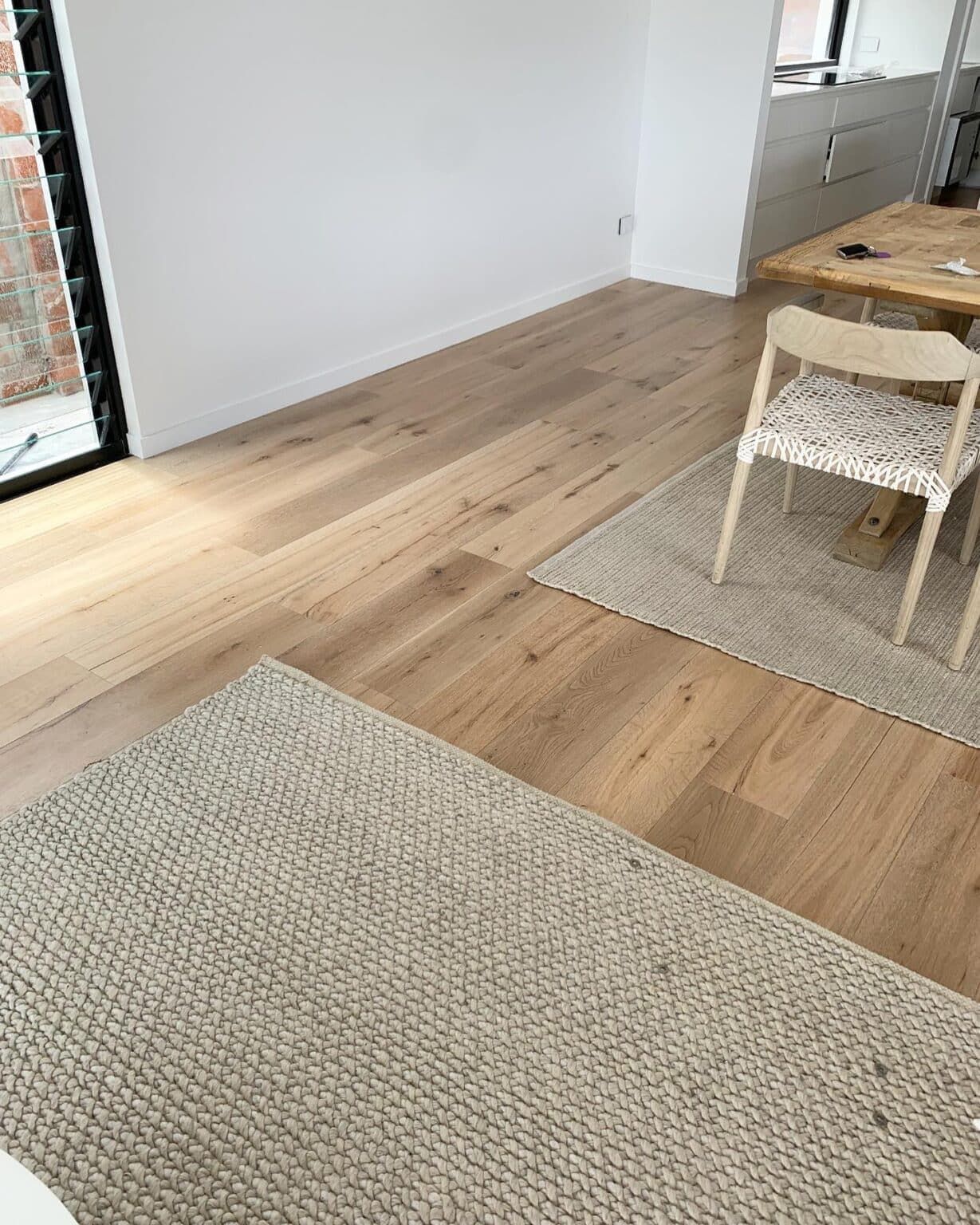 A Living Room With Hardwood Floors, a Rug, Chairs and a Table — Totally Flooring Gold Coast In Bundall, QLD