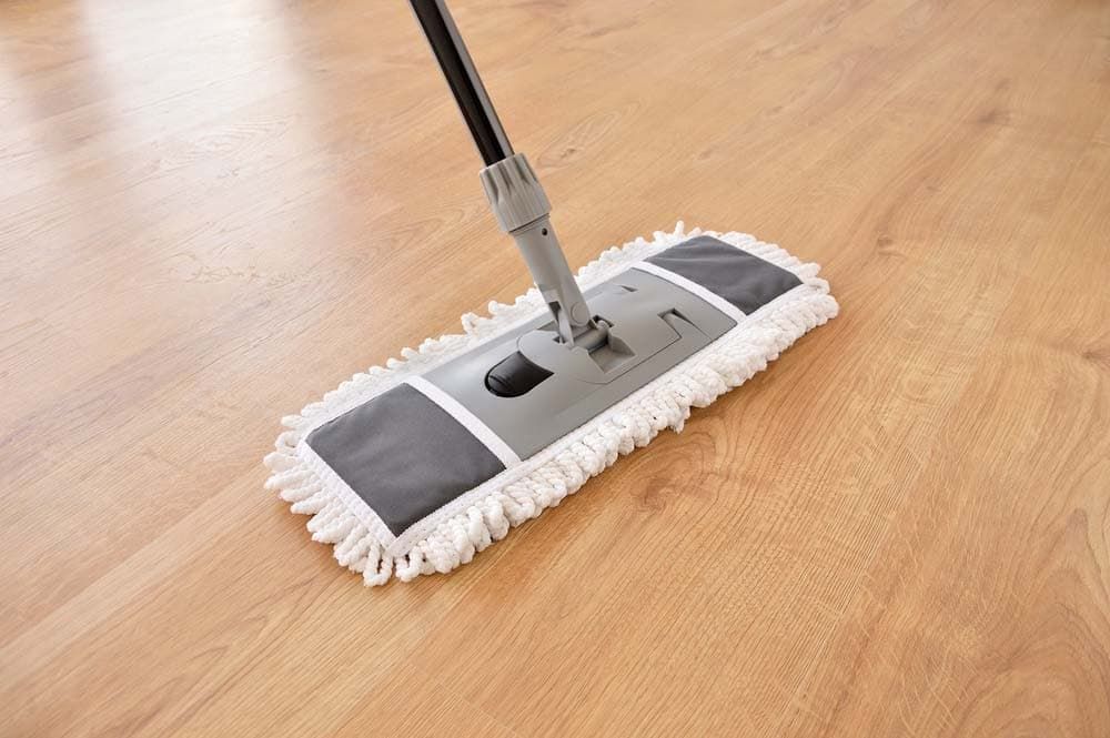 A Mop is Sitting on a Wooden Floor — Totally Flooring Gold Coast In Bundall, QLD
