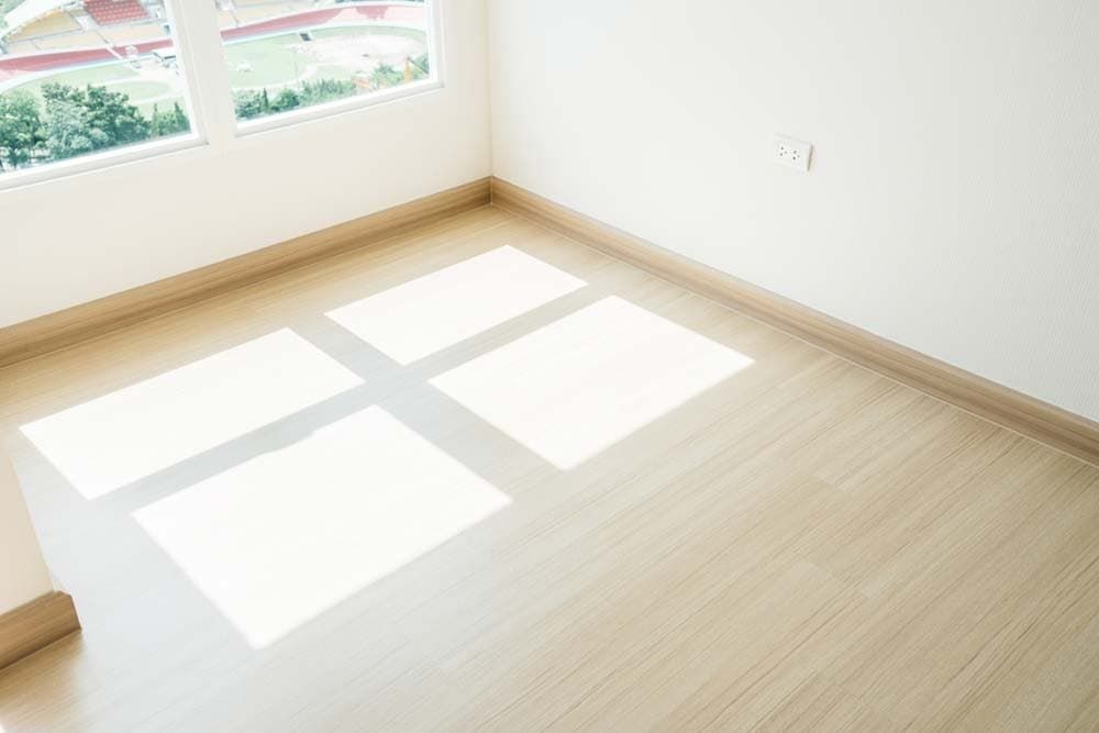 A Room With a Wooden Floor and a Window With a Shadow on the Floor — Totally Flooring Gold Coast In Bundall, QLD