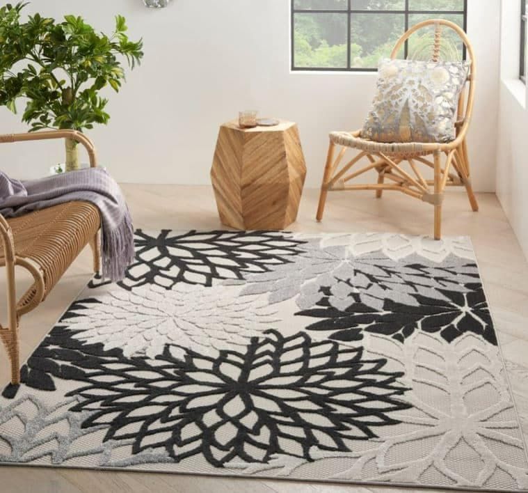 A Black and White Rug in a Living Room With a Wicker Chair — Totally Flooring Gold Coast In Bundall, QLD