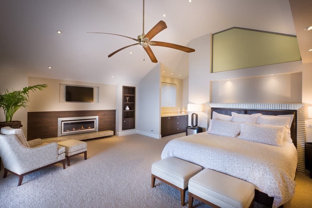 A Bedroom With a Ceiling Fan and a Fireplace — Totally Flooring Gold Coast In Bundall, QLD