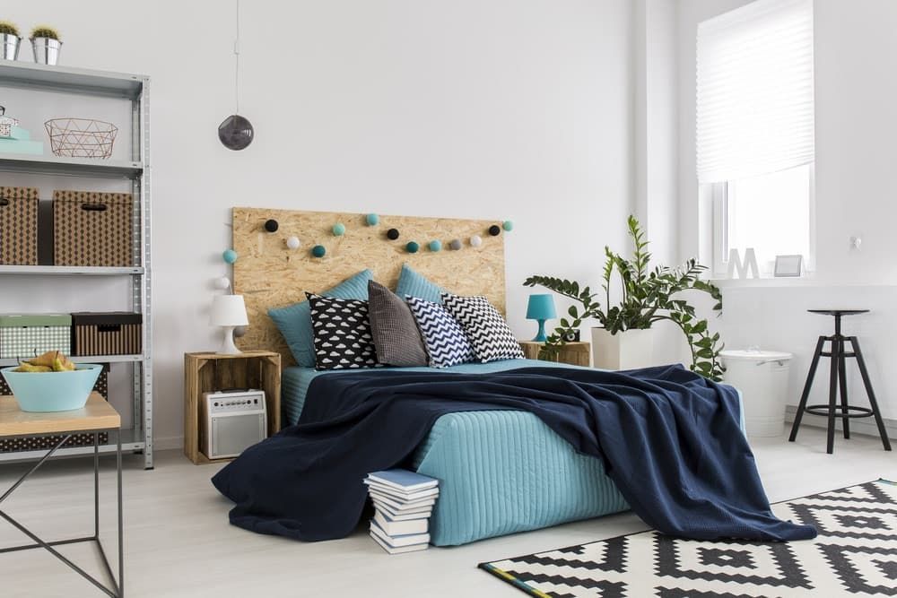 There is a Bed in the Middle of the Room With a Wooden Headboard — Totally Flooring Gold Coast In Bundall, QLD