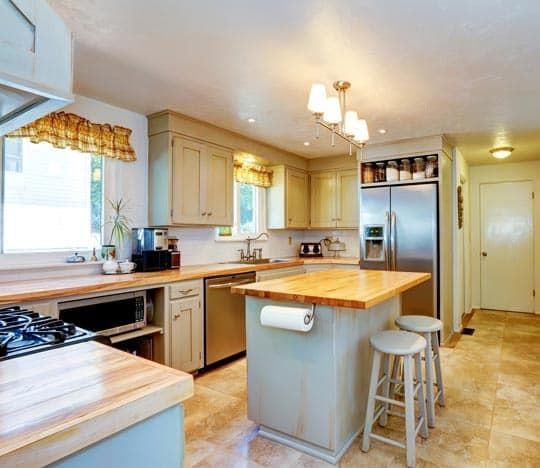 A Kitchen With a Large Island and Stools — Totally Flooring Gold Coast In Bundall, QLD