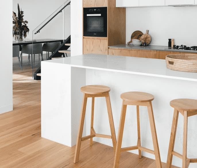 A Kitchen With Wooden Stools and a White Counter Top — Totally Flooring Gold Coast In Bundall, QLD