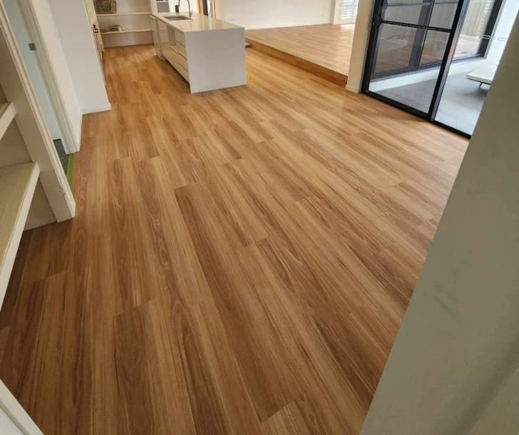 A Living Room With a Wooden Floor and a Sliding Glass Door — Totally Flooring Gold Coast In Bundall, QLD
