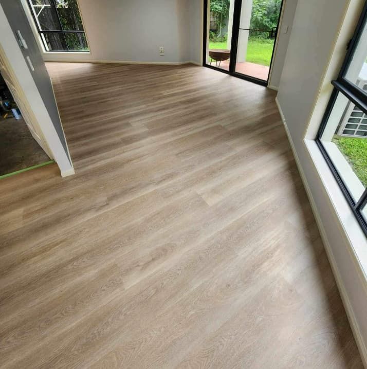 A Living Room With a Wooden Floor and a Large Window — Totally Flooring Gold Coast In Bundall, QLD