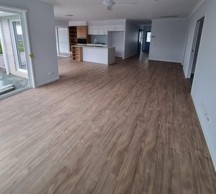 A Living Room With Hardwood Floors and a Kitchen in the Background — Totally Flooring Gold Coast In Bundall, QLD