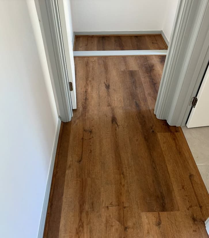 A Hallway With a Wooden Floor and a White Door — Totally Flooring Gold Coast In Bundall, QLD