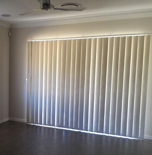 A Living Room With a Ceiling Fan and White Vertical Blinds — Totally Flooring Gold Coast In Bundall, QLD
