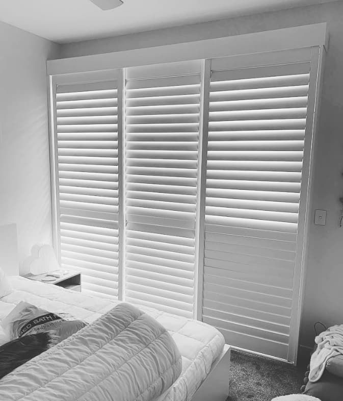 A Black and White Photo of a Bedroom With Shutters on the Windows — Totally Flooring Gold Coast In Bundall, QLD