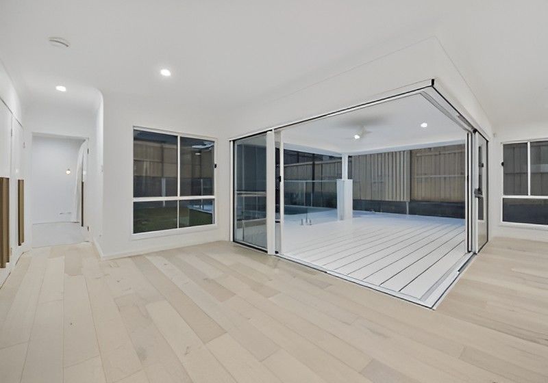 Bright Empty Indoor Outdoor Room with White Floors, Large Sliding Glass Doors, and A Covered Patio — Totally Flooring Gold Coast In Bundall, QLD