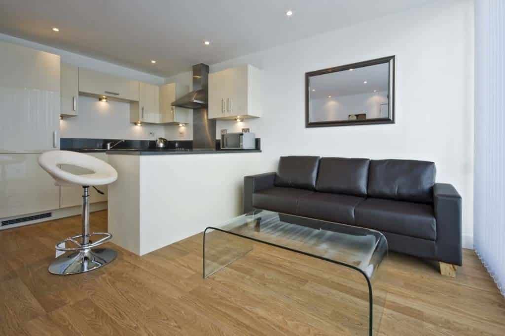 A Living Room With a Black Couch and a Glass Coffee Table — Totally Flooring Gold Coast In Yarrabilba, QLD