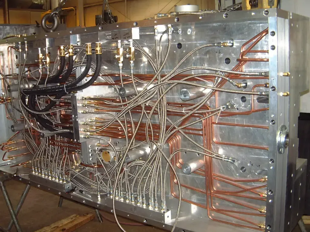 Complex metal machinery with copper pipes and wiring in an industrial workshop