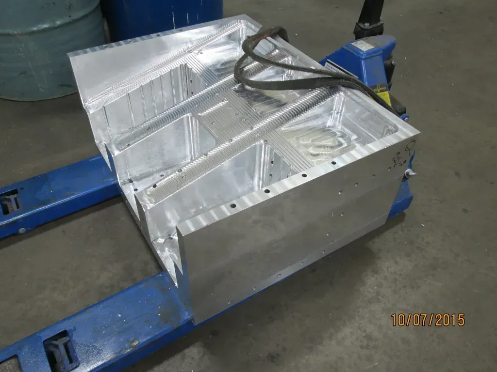 Aluminum fuel tank on a workshop floor, strapped to a blue pallet jack.