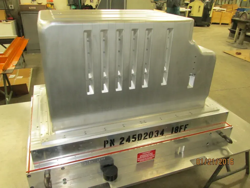 Industrial metal machine cabinet with vents and red stripe in a workshop