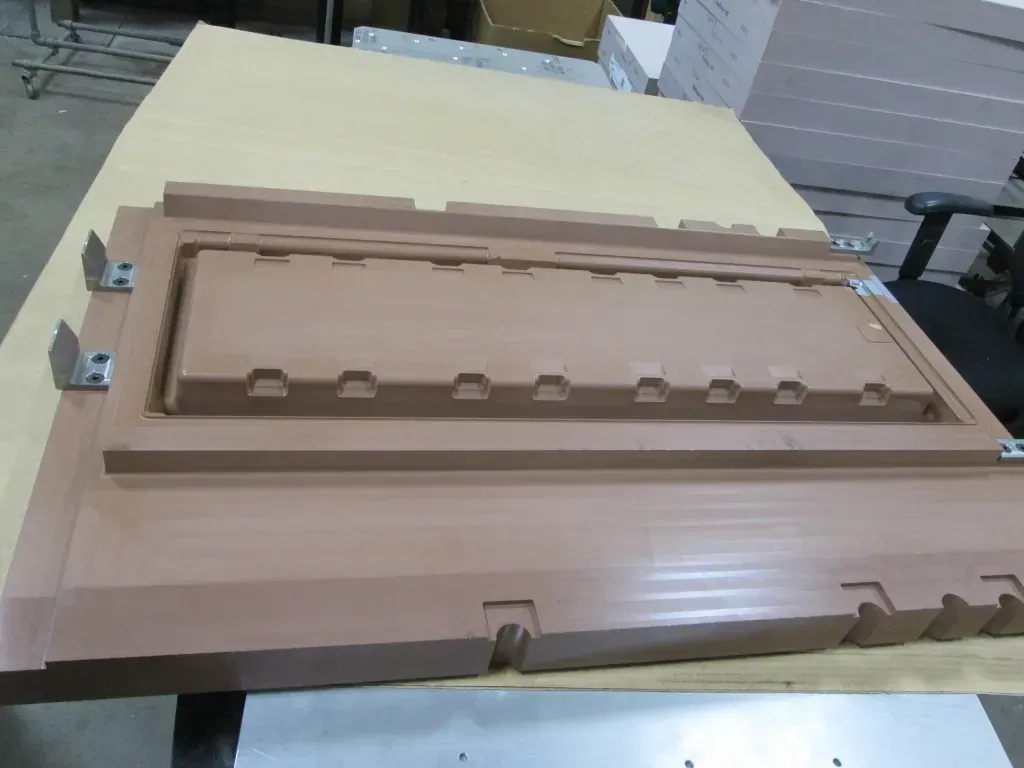 Wooden architectural model of a building facade with a raised central panel and small columns