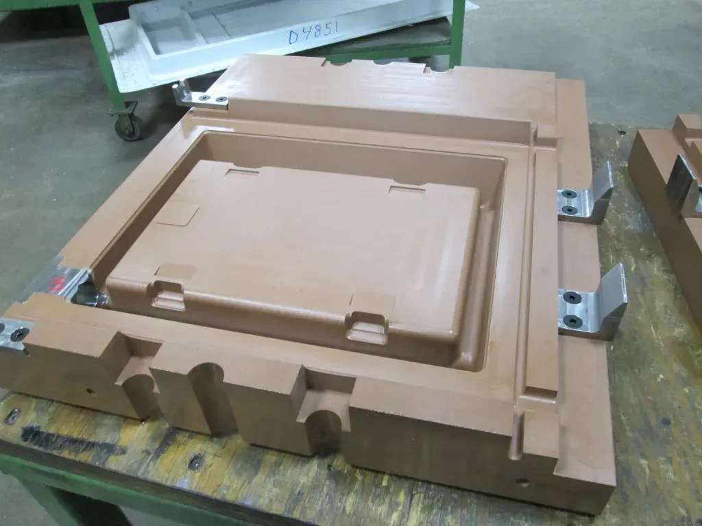Brown foam packaging inserts stacked on a worktable in a workshop