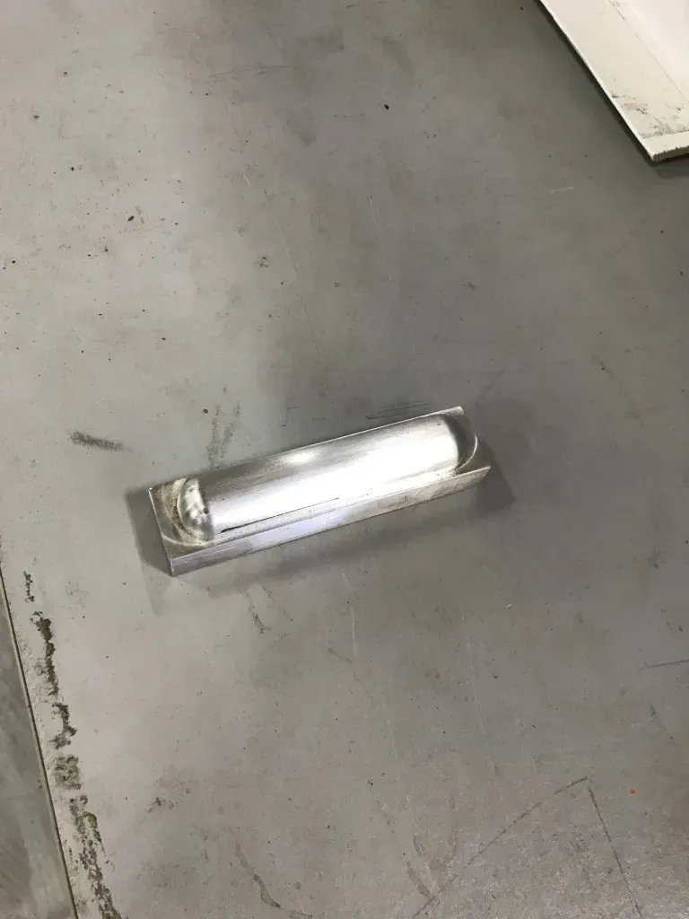 White fluorescent light fixture mounted on a gray concrete surface