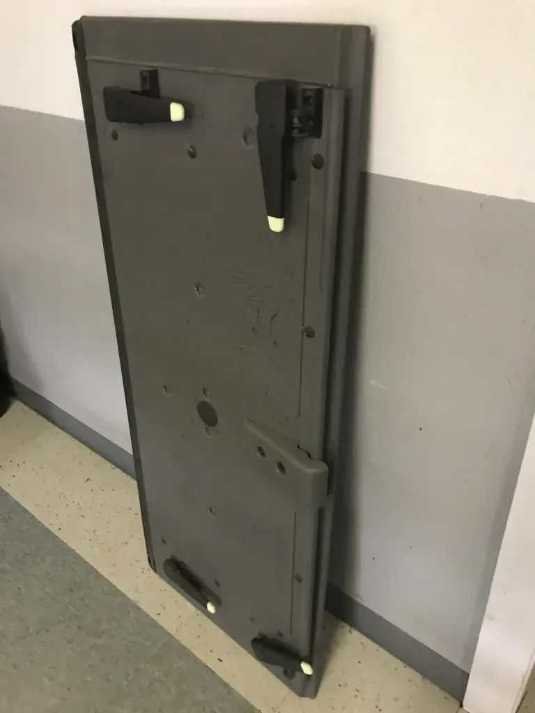 Gray folded table leaning against a wall in a hallway