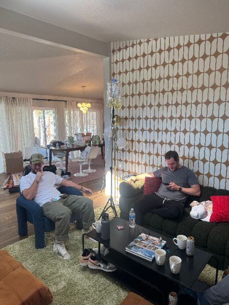A group of men are sitting on a couch in a living room.