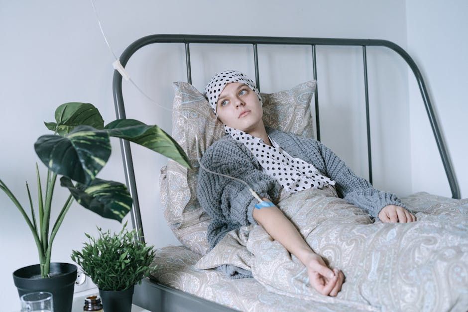 A woman is laying in a bed with a bandage on her head.