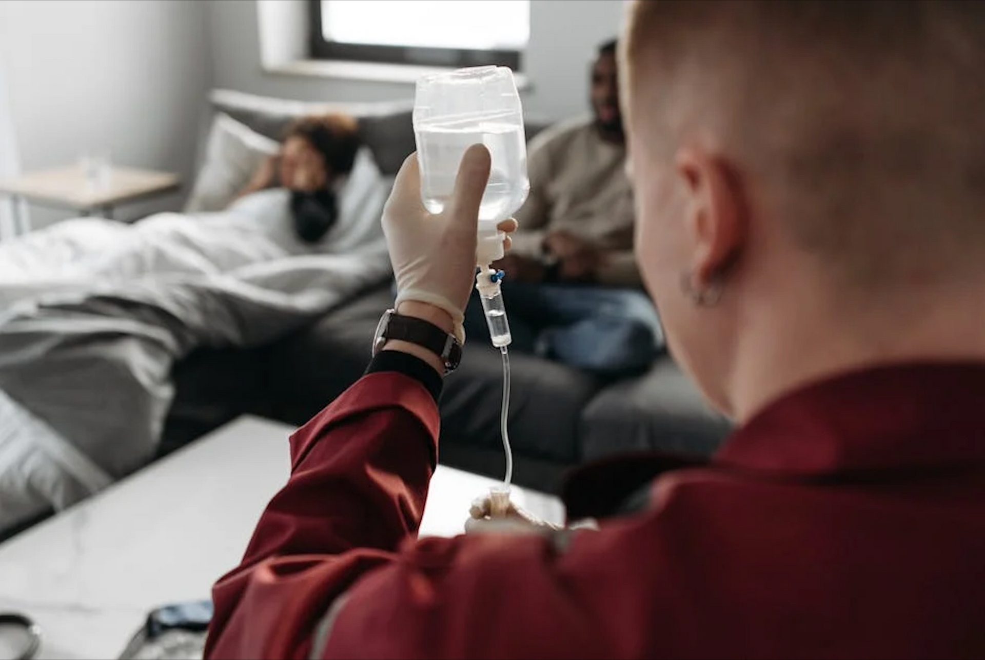 A man is holding a bottle of water with a syringe attached to it.