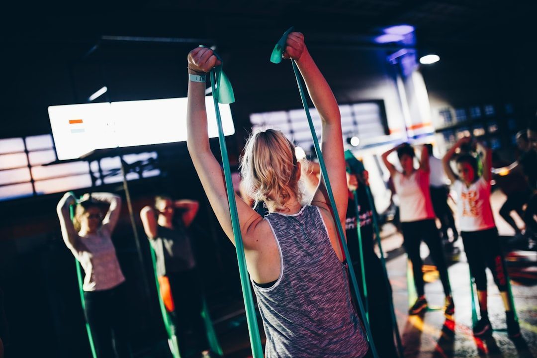 A group of people are doing exercises with resistance bands in a gym.